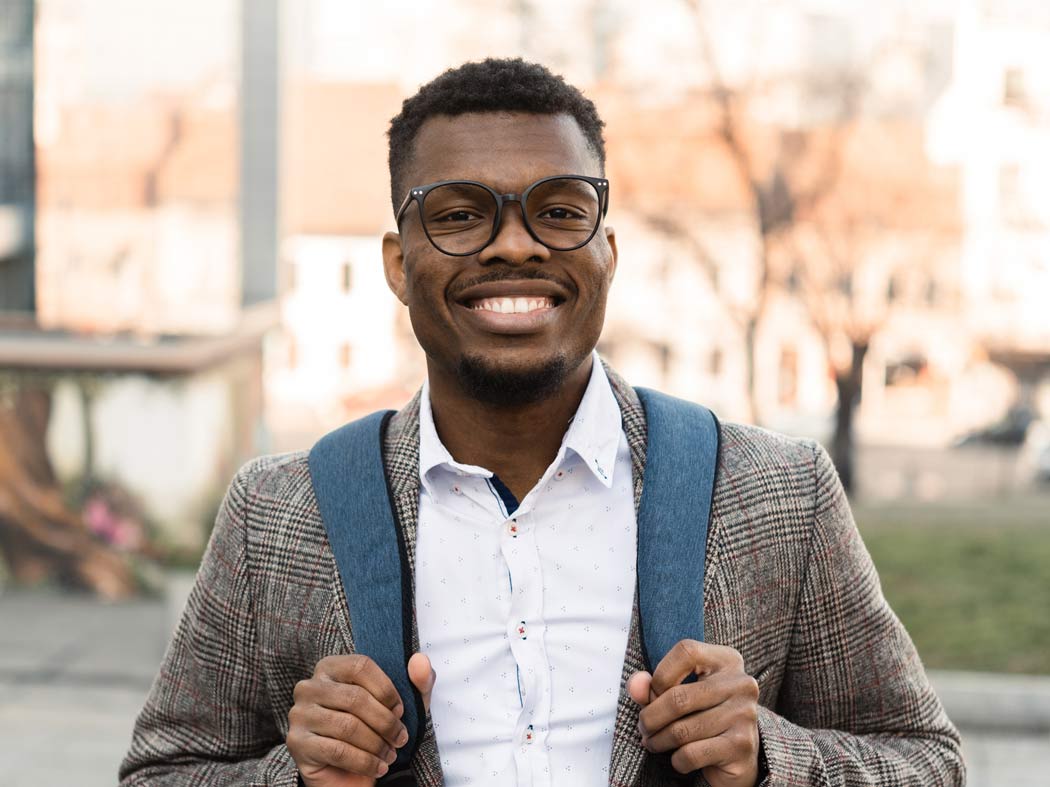 Student smiling with a bagpack